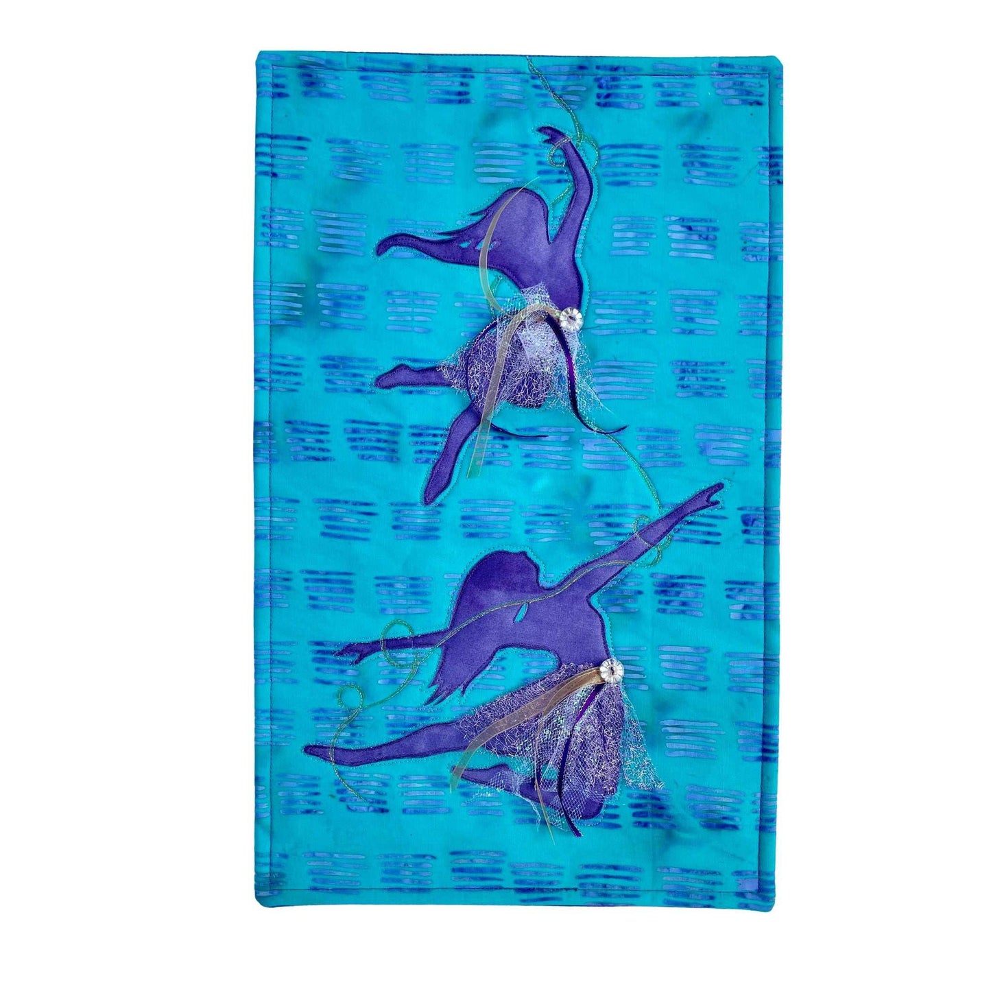 Purple Dancer: A Silhouette Art Quilt by Miki Howell is a textile artwork on a blue patterned background, featuring two Purple Dancers with outstretched arms, crafted with fabric collage, textured fabric, and bead embellishments.