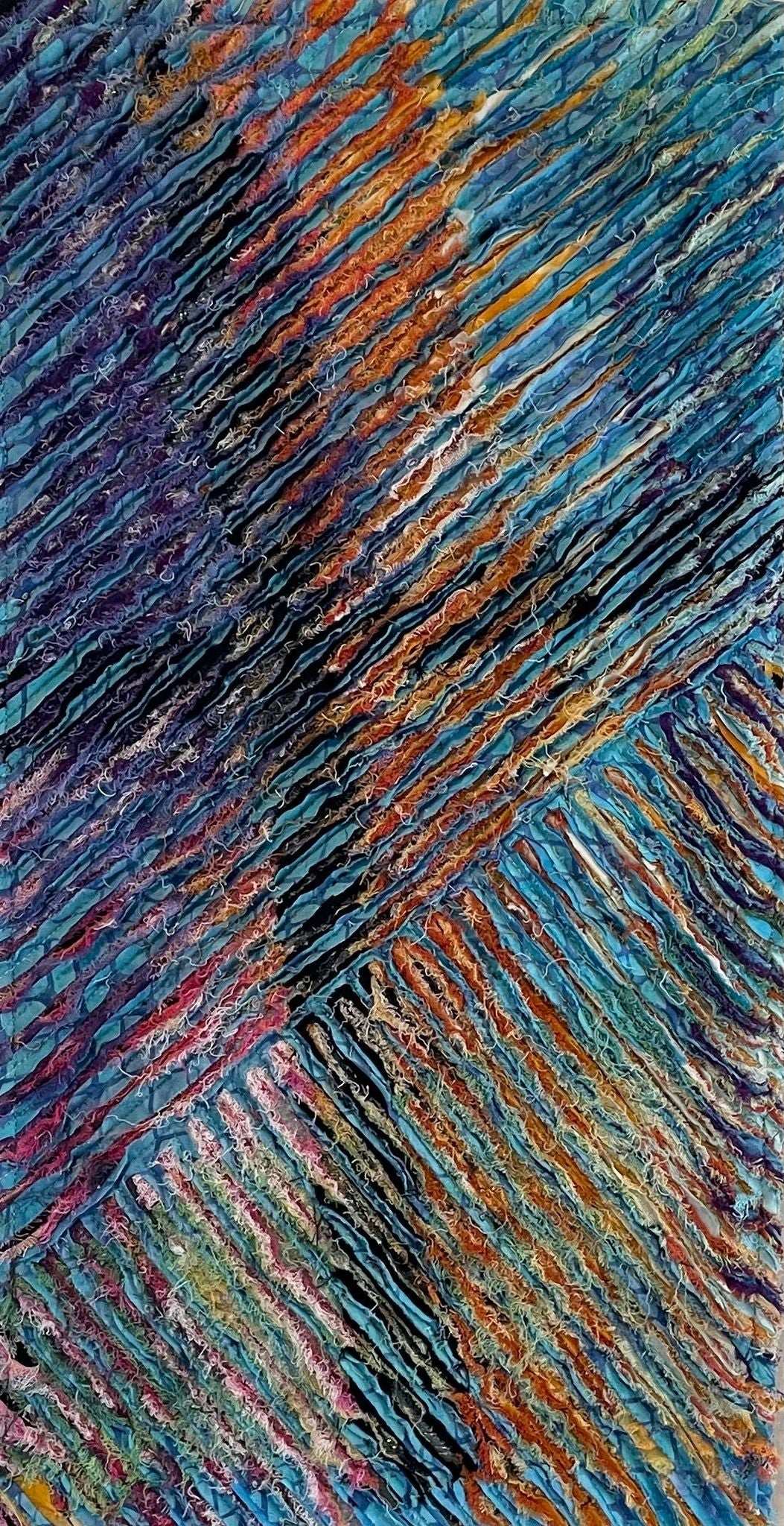 For Each One of Us: Art Quilt by Miki Howell features textured, diagonal ridges in vibrant blue, orange, purple, and teal. Layered patterns evoke depth and movement, echoing the intricate style of hand-dyed textile art.