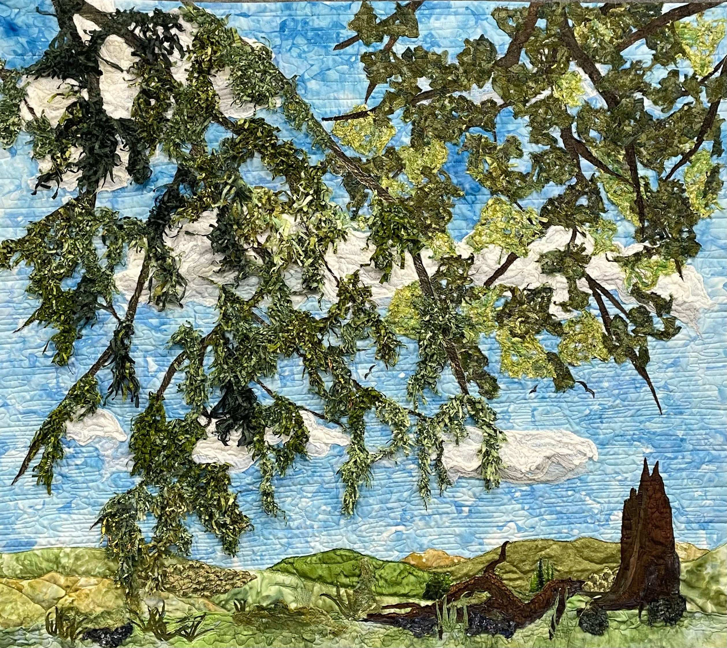 Looking Up: Landscape Textile Art Wall Hanging by Miki Howell features leafy branches against a blue sky, green hills, and a tree stump—a distinctive piece to enhance your space.