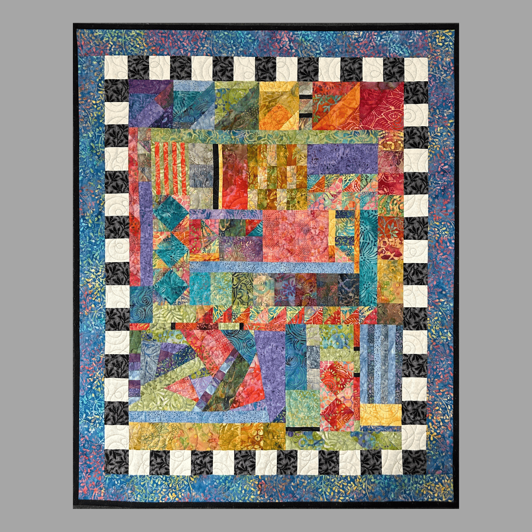 Taming Chaos: Quilted Wall Art by Mary Cantore features vibrant patchwork and geometric patterns, bordered by a black and white checkerboard and blue edge, displayed against a gray background.