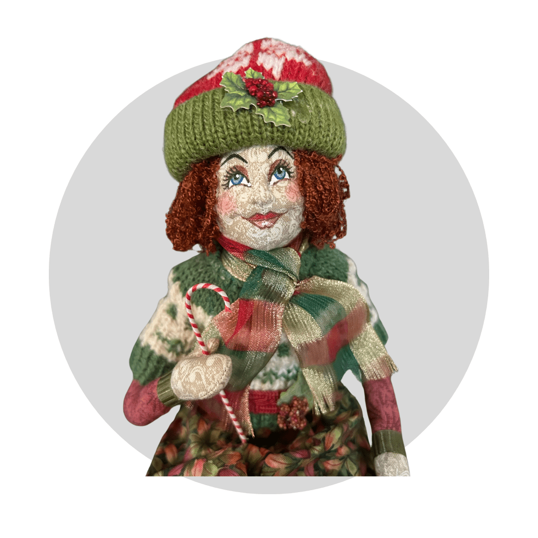 The Yuleve: Art Doll by Mary Cantore is a festive handcrafted fabric figurine with red hair, a green knit holly hat, matching scarf, candy cane, rosy cheeks, and Christmas-themed clothing.