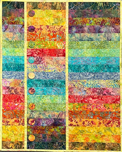 Topsy Turvy: Quilted Wall Art by Mary Cantore showcases vibrant batik strips—yellow, orange, red, green, blue, and purple—with three beige sashing stripes and circular appliques on the left panel. A striking piece for home decor.