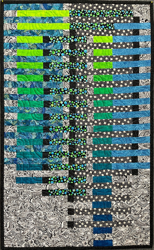 Water Reflections: Quilted Wall Art by Mary Cantore features alternating strips of blue, green, black, and white fabrics. Colorful on the left and transitioning to black and white swirls and florals—ideal home décor.