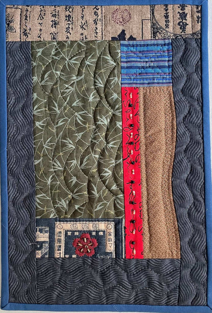 Memories of Japan: Art Quilt by Miki Howell is a cotton wall quilt with green, red, brown, and blue rectangles, Japanese text prints, wavy lines, a red flower accent, and a dark wavy-patterned border.