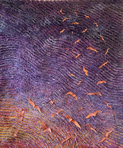 The Carry the Light wall hanging by Miki Howell features undulating purple and red waves, scattered with orange brocade birds resembling origami. Crafted from hand-dyed fabrics, it evokes movement and depth against a dark background.