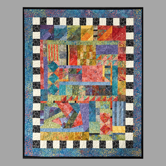 Taming Chaos: Quilted Wall Art by Mary Cantore features vibrant patchwork and geometric patterns, bordered by a black and white checkerboard and blue edge, displayed against a gray background.