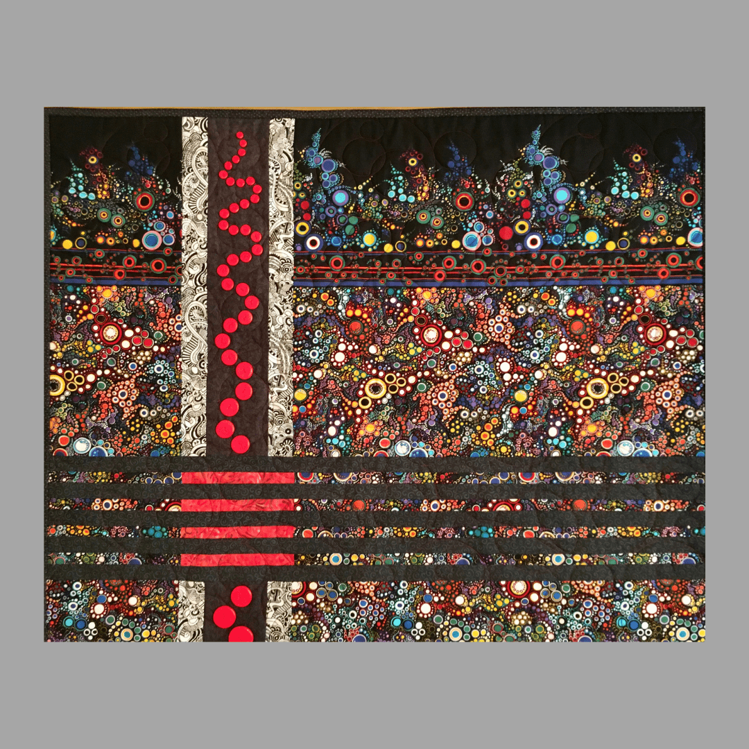The Effervescent Sea: Quilted Wall Art by Mary Cantore features vibrant patterns—multicolored circles, swirls, and black and red lines—with a bold vertical red stripe and red dots on a gray quilted background.